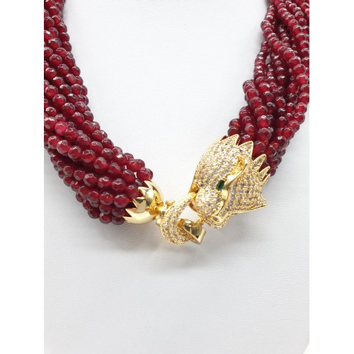 30 - A 15 row statement necklace with faceted rubies and a large Cartier Panther style clasp. Rubies are ... 