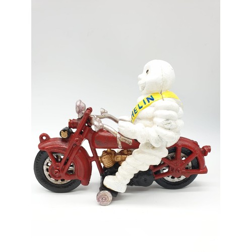 20 - A collector’s item, French, cast iron, MITCHELIN MAN, on a motorbike. Wheels turning with special so... 