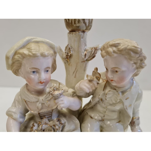 72 - Pair of ceramic candlesticks with figures in Victorian themed fashion. Height 19cm.