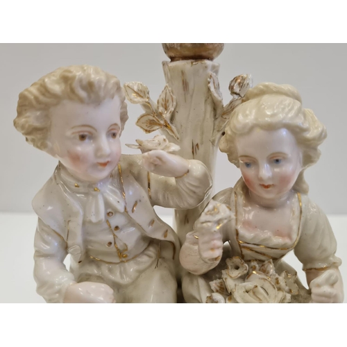 72 - Pair of ceramic candlesticks with figures in Victorian themed fashion. Height 19cm.