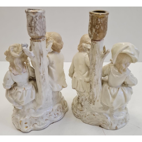 72 - Pair of ceramic candlesticks with figures in Victorian themed fashion. Height 19cm.