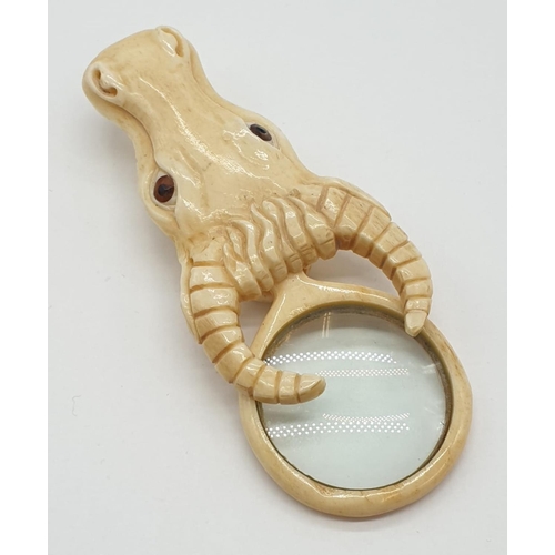 178 - A vintage bone magnifying glass attached to a bone bull's head.