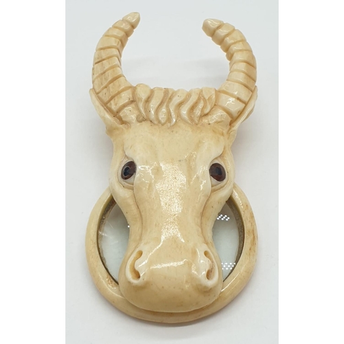 178 - A vintage bone magnifying glass attached to a bone bull's head.