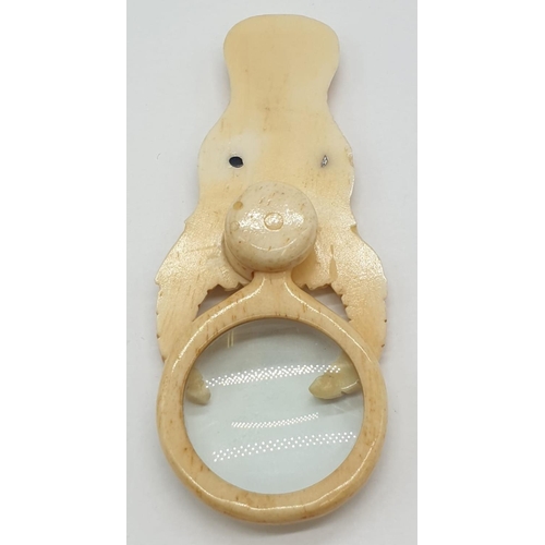 178 - A vintage bone magnifying glass attached to a bone bull's head.