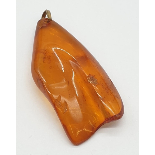 184 - Three amber pendants.