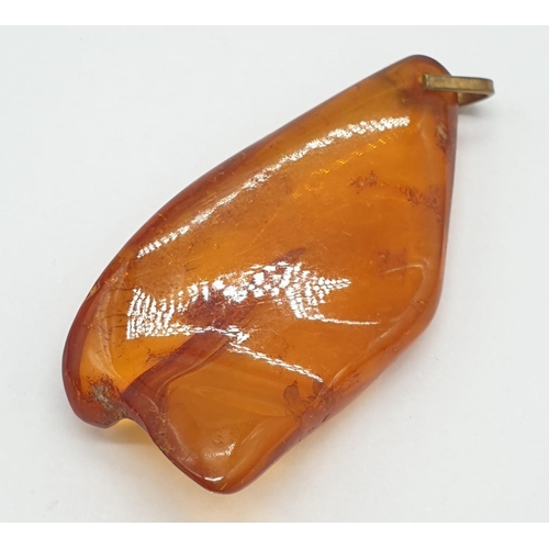 184 - Three amber pendants.