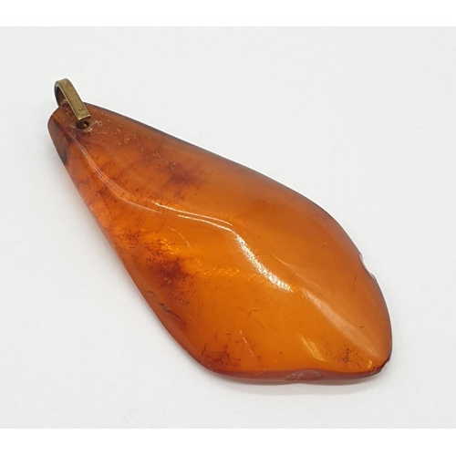 184 - Three amber pendants.