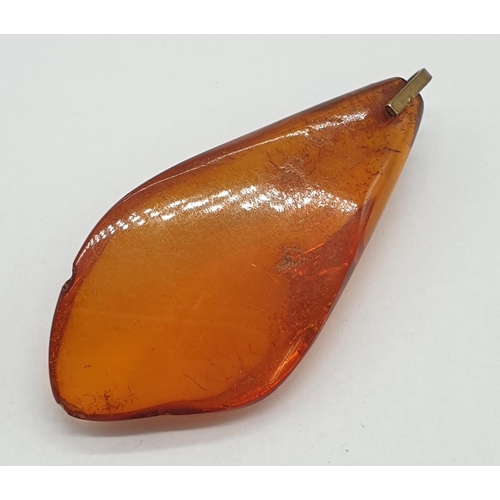 184 - Three amber pendants.