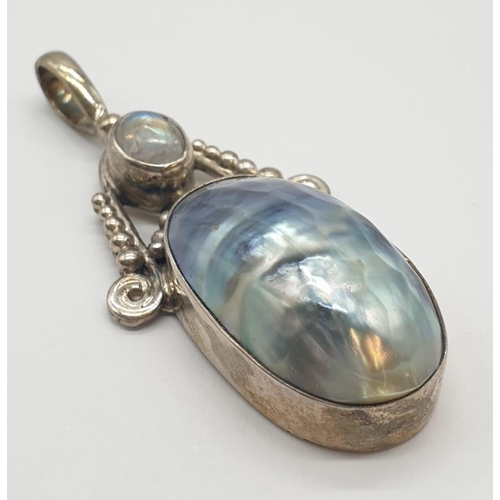 353 - Two large silver pendants one with mother of pearl, 38.2 grams total and 4.5cm long approx.