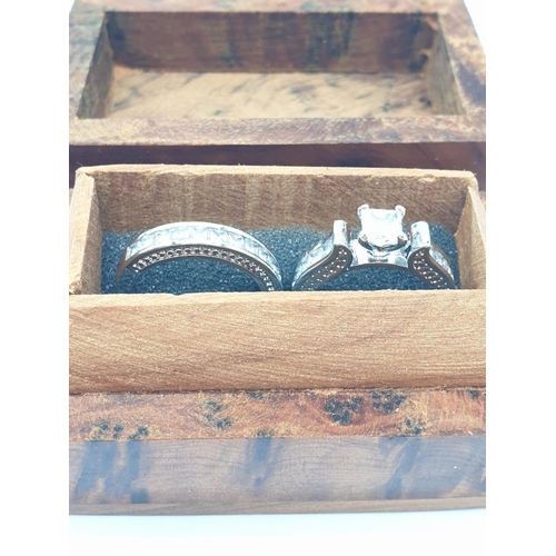 119 - A pair of rings with cubic zirconia, presented in a beautiful wooden box. 
Ring size: N