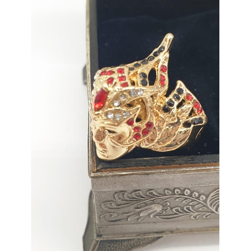 47 - A ring depicting a Venetian Carnival Mask and a pair of earrings in a metal, Renaissance style box. ... 