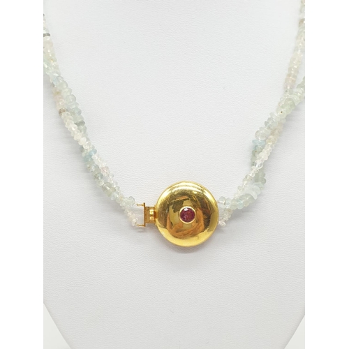 373 - An aquamarine necklace with a gold plated silver clasp, tourmaline stone at the centre of clasp. Som... 