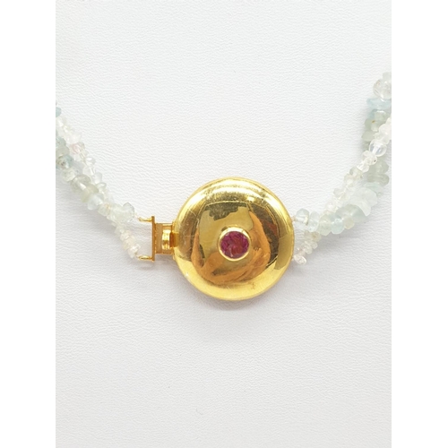 373 - An aquamarine necklace with a gold plated silver clasp, tourmaline stone at the centre of clasp. Som... 