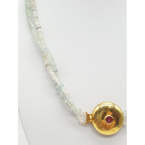 373 - An aquamarine necklace with a gold plated silver clasp, tourmaline stone at the centre of clasp. Som... 