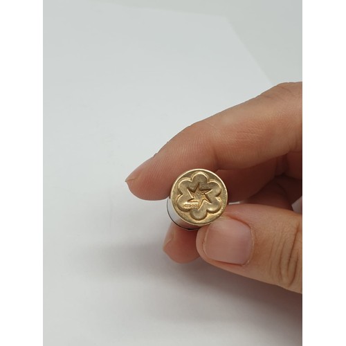 289 - 9ct gold charm/pendant featuring a rolled up stamp. Length of charm 2.5cm. Weight 2.78