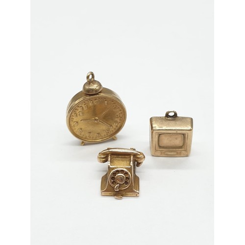 338 - Three 9ct gold charms/pendants of an old fashioned telephone, tv and alarm clock. Size of Clock is 2... 