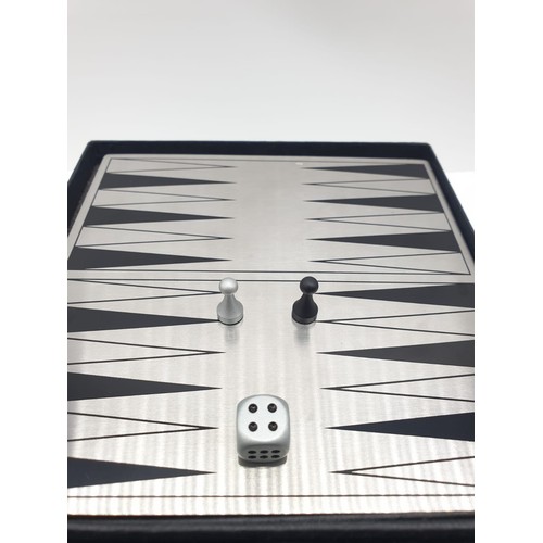 187 - A mini magnetic backgammon board with pieces. 14cm x 14cm.