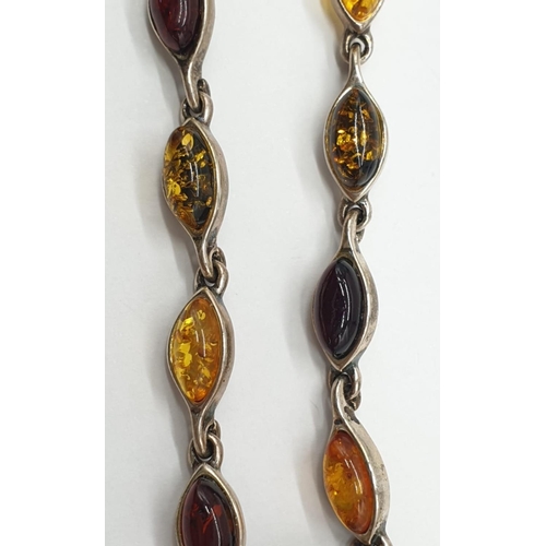 100 - Silver and Amber bracelet, having various shades of amber stones in silver set form. 18cm approx.