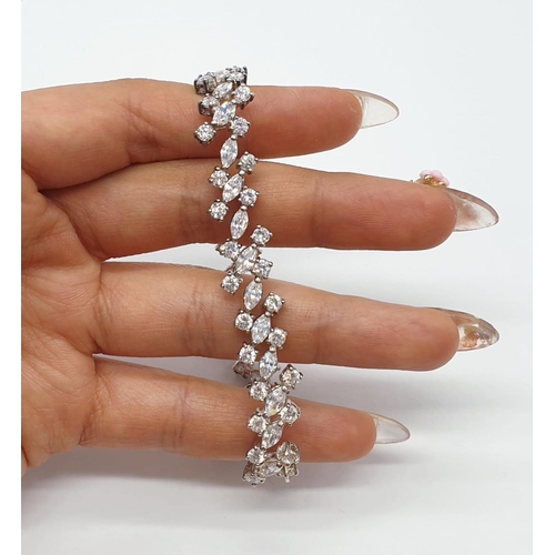 106 - Silver tennis bracelet with stones set in trilogy form along the length of the bracelet. Bracelet le... 