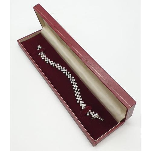 106 - Silver tennis bracelet with stones set in trilogy form along the length of the bracelet. Bracelet le... 