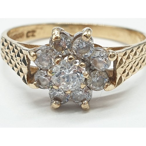 394 - 9ct Gold zirconia cluster ring ,having chased design work to shoulders. Boxed. Weight 2.3 grams appr... 