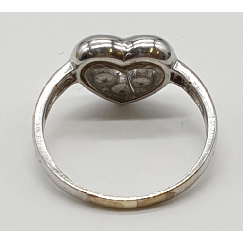 144 - 9ct white gold heart ring with 3 small moving diamonds to centre. Small crack to back. Size J. Weigh... 