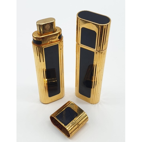 647 - 2 x Golden perfume bottles made by Cartier in a leather case. 9cm high.