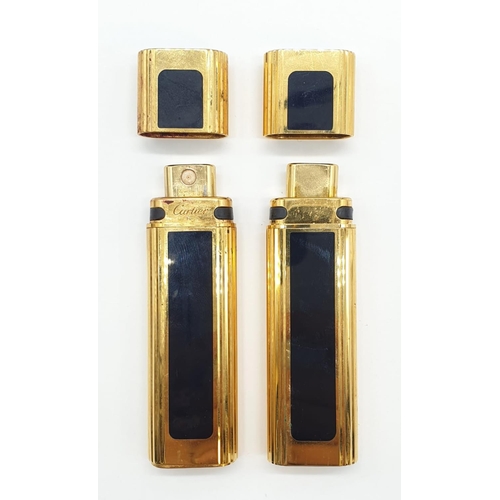 647 - 2 x Golden perfume bottles made by Cartier in a leather case. 9cm high.