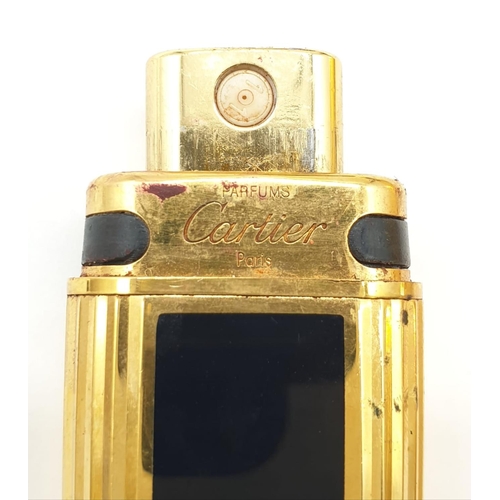 647 - 2 x Golden perfume bottles made by Cartier in a leather case. 9cm high.