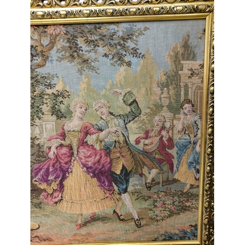 269 - A French Rococo tapestry depicting gaiety in the garden, in a gold baroque style frame. 100 x 54cm.