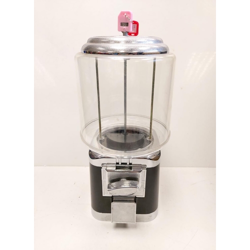 513 - A classic Gumball machine. Coin operated, locking key on top. Clear plastic with black plastic/metal... 