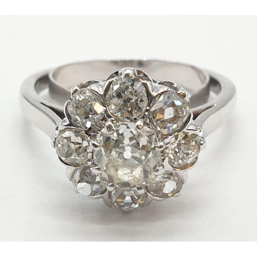 63 - Platinum diamond cluster ring in floral design, weight 5.58g and size P with over 3ct diamonds.