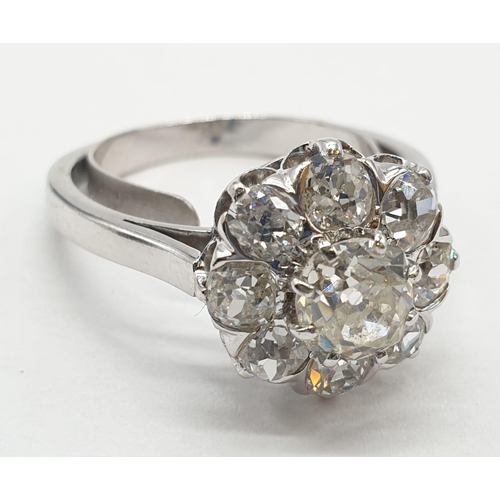 63 - Platinum diamond cluster ring in floral design, weight 5.58g and size P with over 3ct diamonds.