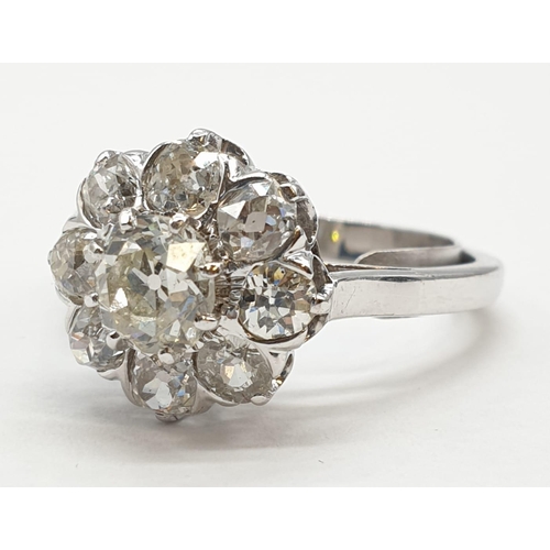 63 - Platinum diamond cluster ring in floral design, weight 5.58g and size P with over 3ct diamonds.