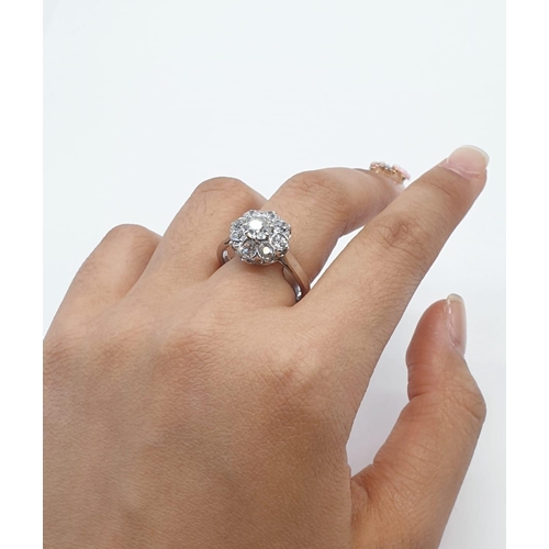 63 - Platinum diamond cluster ring in floral design, weight 5.58g and size P with over 3ct diamonds.