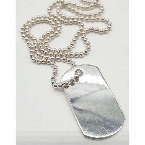 555 - Sterling Silver dog tag on 49cm long silver chain, weight 16.5g approx