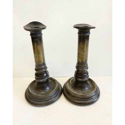 663 - A pair of Victorian brass candlesticks, engraved with VR next to crown. 22cm high.