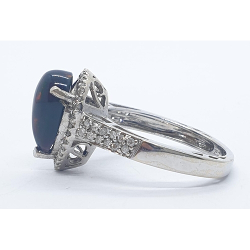 1000 - A 18ct white gold and diamond ring with black opal centre stone. Weight 3.6g, Size N.