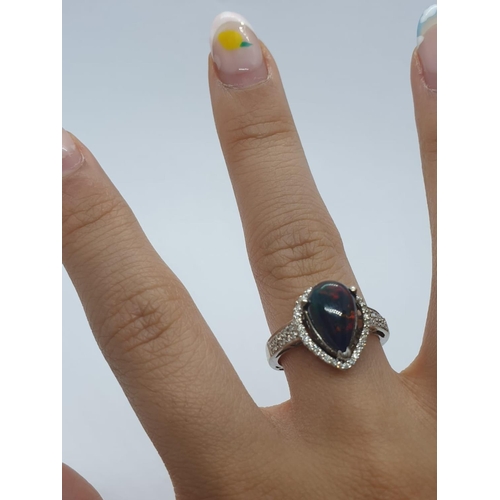 1000 - A 18ct white gold and diamond ring with black opal centre stone. Weight 3.6g, Size N.