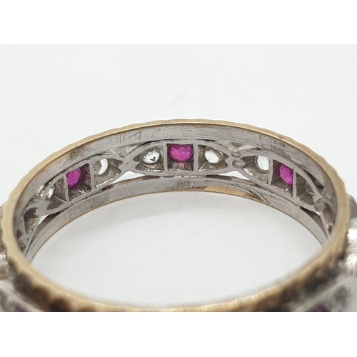 1009 - 9ct ruby and white sapphire eternity ring. 2.6g in weight. Size  O.