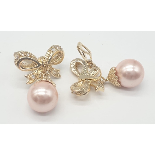 64 - A two rows of pink pearls necklace and earrings set in a presentation box. Necklace length: 44cm, ea... 