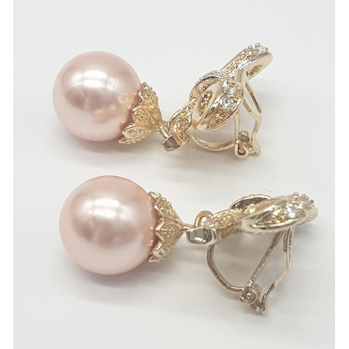 64 - A two rows of pink pearls necklace and earrings set in a presentation box. Necklace length: 44cm, ea... 