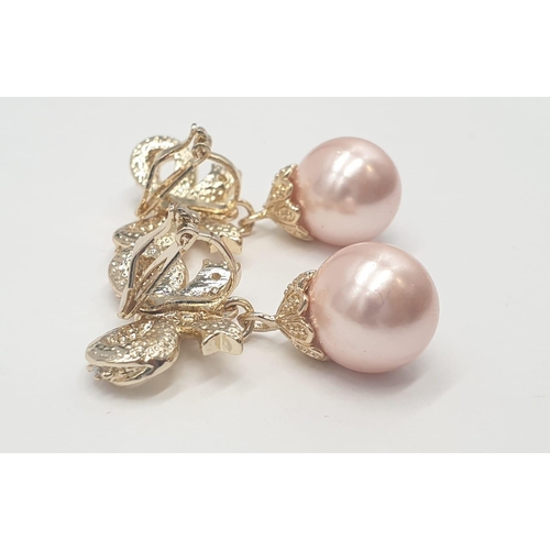 64 - A two rows of pink pearls necklace and earrings set in a presentation box. Necklace length: 44cm, ea... 