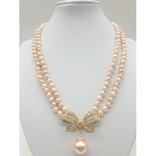 64 - A two rows of pink pearls necklace and earrings set in a presentation box. Necklace length: 44cm, ea... 