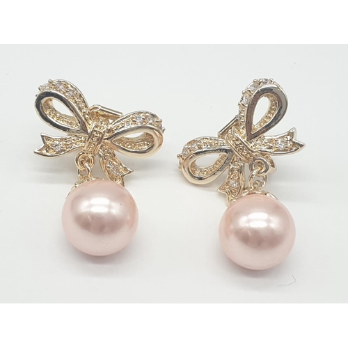 64 - A two rows of pink pearls necklace and earrings set in a presentation box. Necklace length: 44cm, ea... 