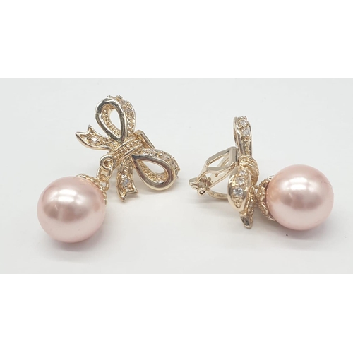 64 - A two rows of pink pearls necklace and earrings set in a presentation box. Necklace length: 44cm, ea... 