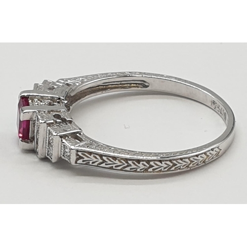 113 - An art deco style ladies 18ct white gold diamond and ruby (emerald cut) ring. Size N.0.3ct ruby. Tot... 