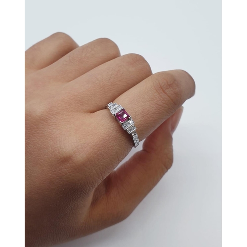 113 - An art deco style ladies 18ct white gold diamond and ruby (emerald cut) ring. Size N.0.3ct ruby. Tot... 