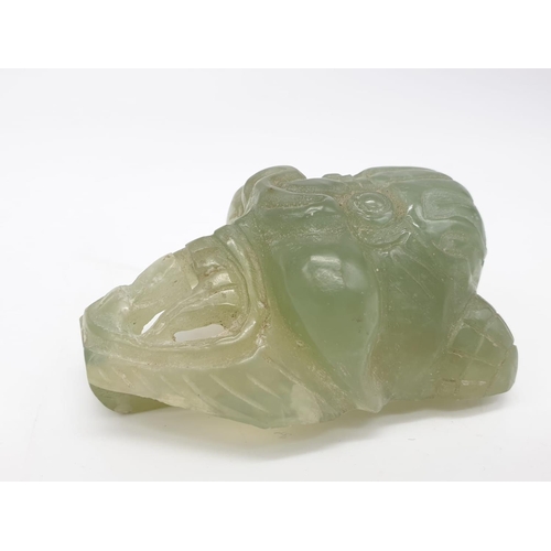 180 - Hard stone belt buckle in the form of an Asian god. 79g in weight, 7cm x 5cm.