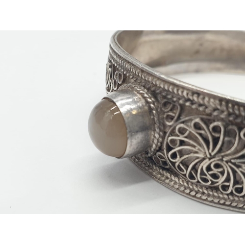 242 - Vintage silver bangle with central moonstone. 21.9g in weight.